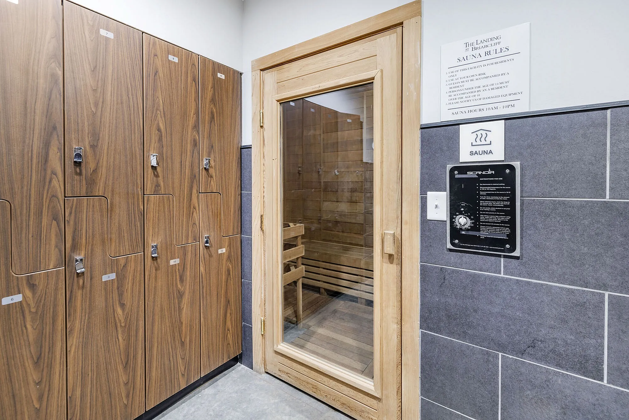 Luxurious apartment amenity featuring a chic wooden sauna and modern locker room for relaxation and convenience.