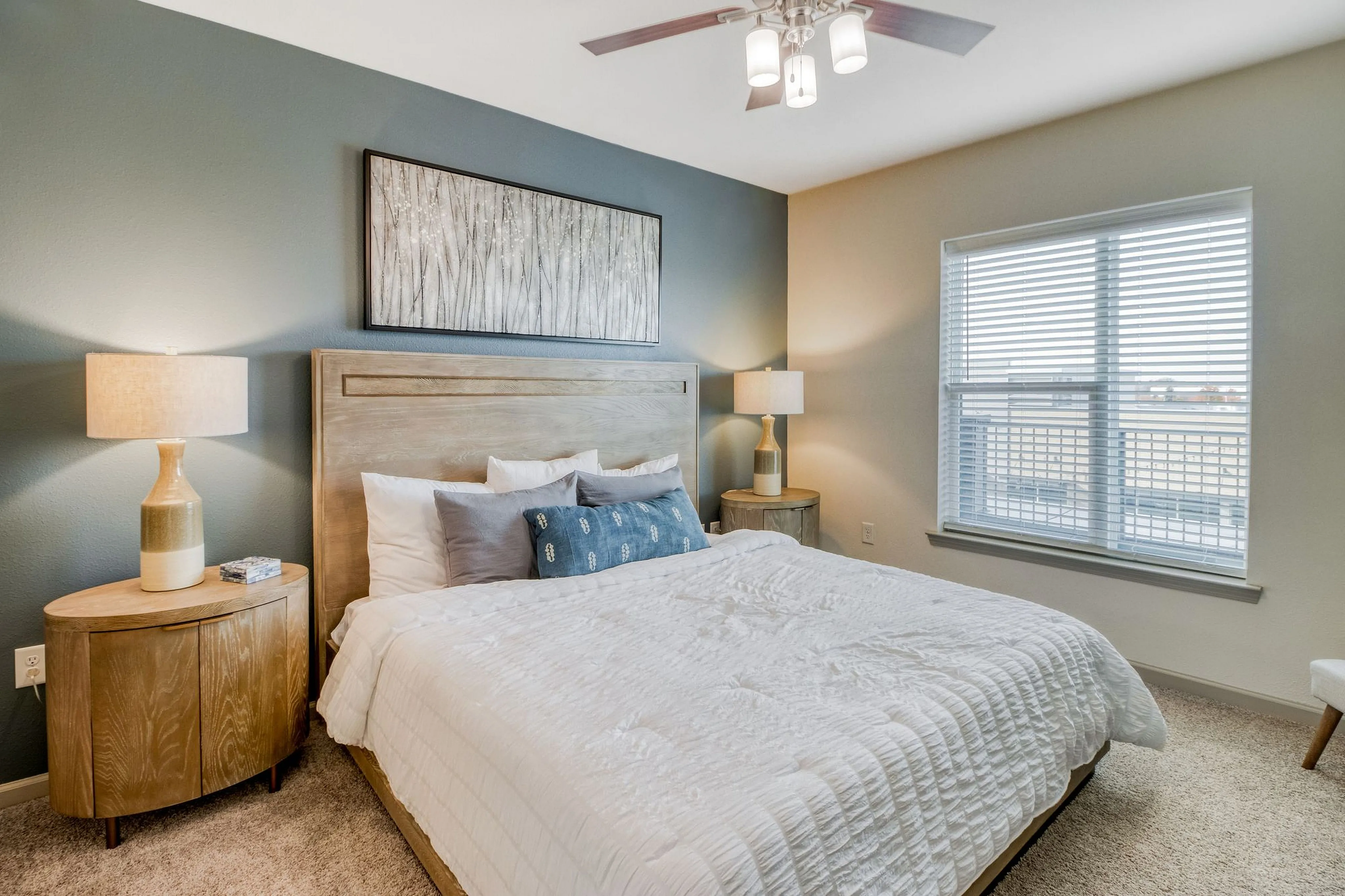 Cozy and inviting bedroom with plush bedding, modern decor, and abundant natural light highlighting a serene ambiance.