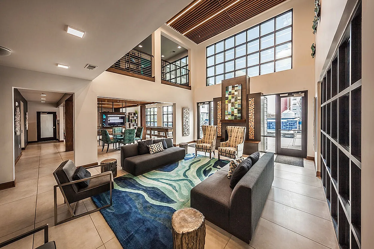 Luxurious open-concept living area with stylish modern furnishings, vibrant artwork, and ample natural light from floor-to-ceiling windows, perfect for elegant entertaining.