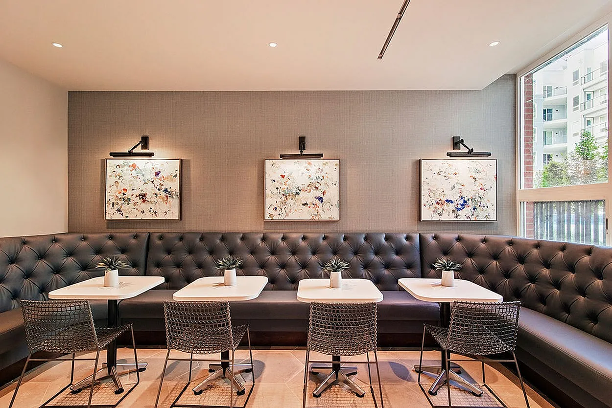Chic communal area with stylish upholstered seating, modern art decor, and abundant natural light.