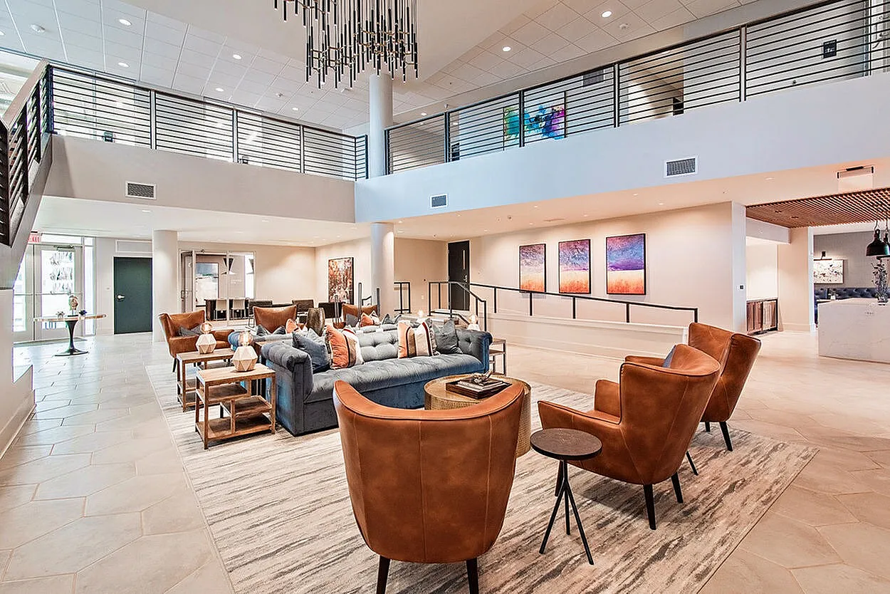 Elegant and inviting open-concept lobby featuring modern leather seating, chic decor, and large artwork on the walls.