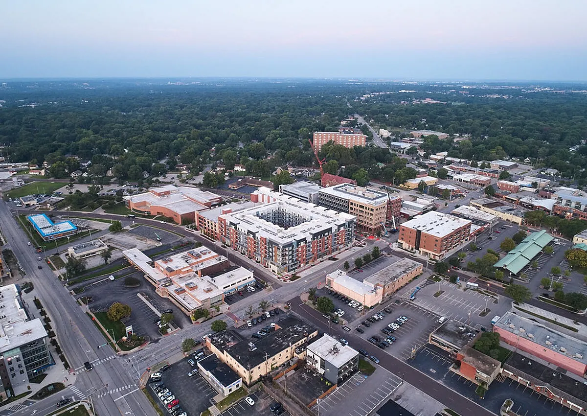 Vibrant aerial view showcasing a modern urban neighborhood with stylish apartment complexes surrounded by lush greenery.