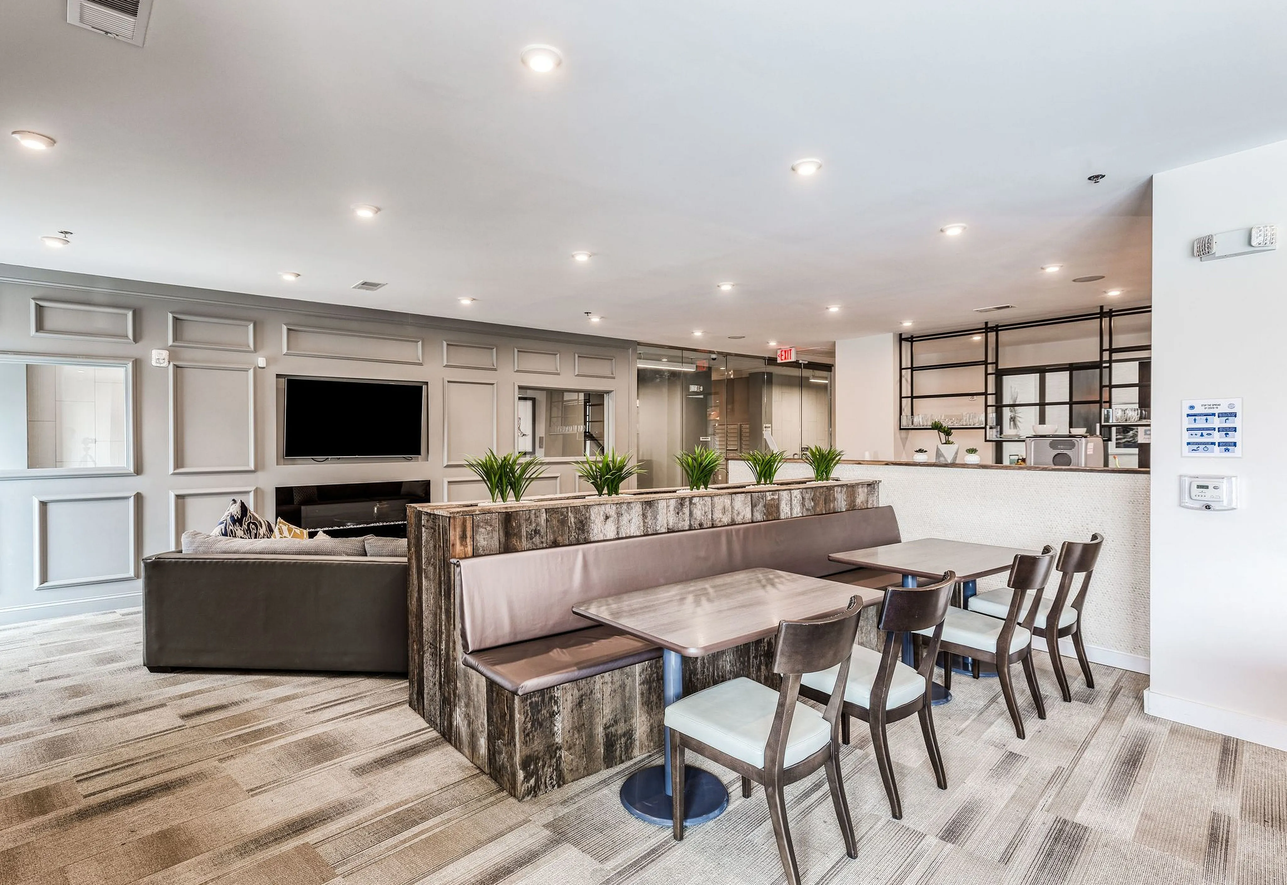 Modern communal space featuring cozy seating, elegant dining area, and stylish decor with natural light.
