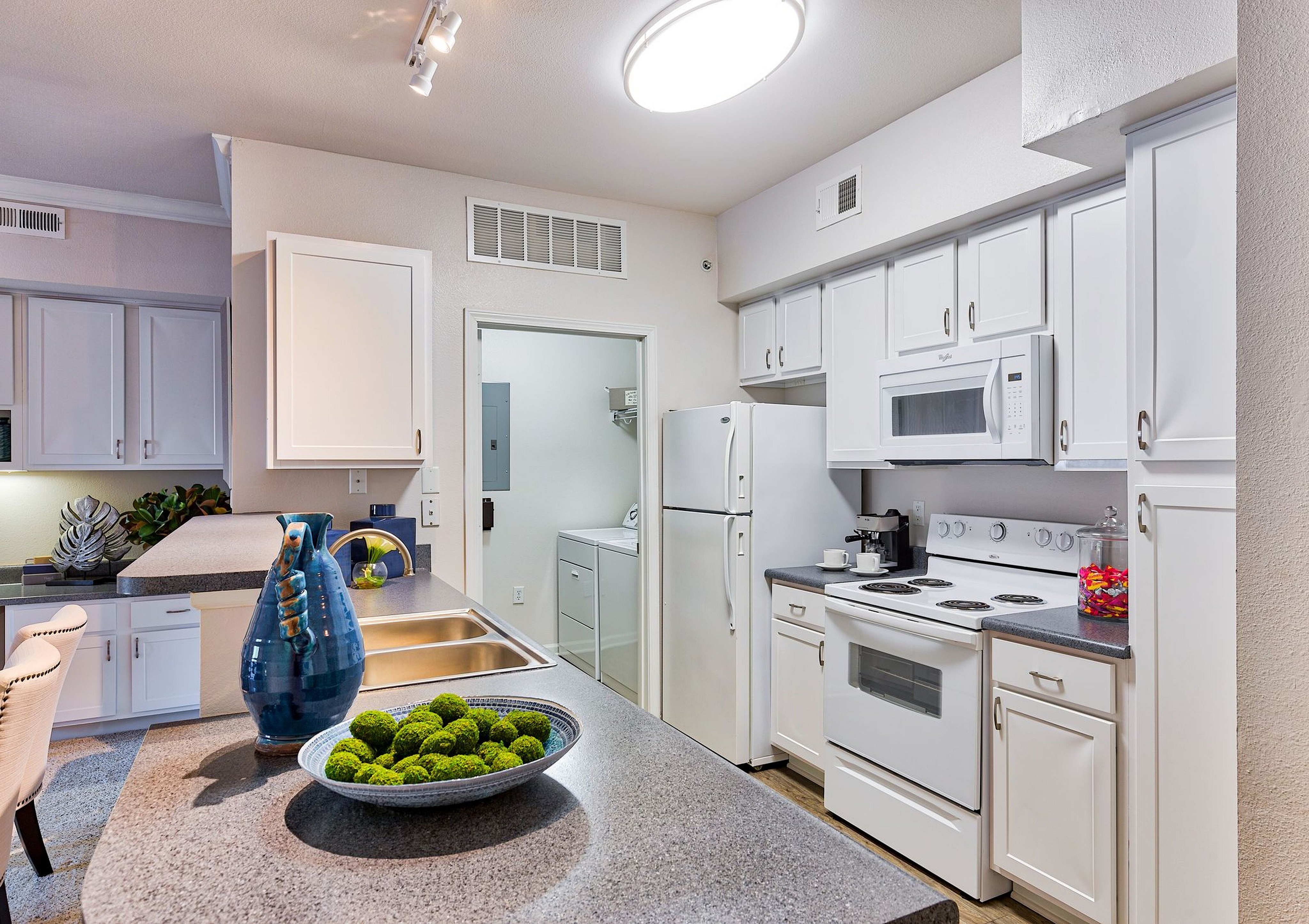 Modern kitchen featuring sleek white cabinetry, elegant countertops, and built-in appliances with a bright, inviting atmosphere.