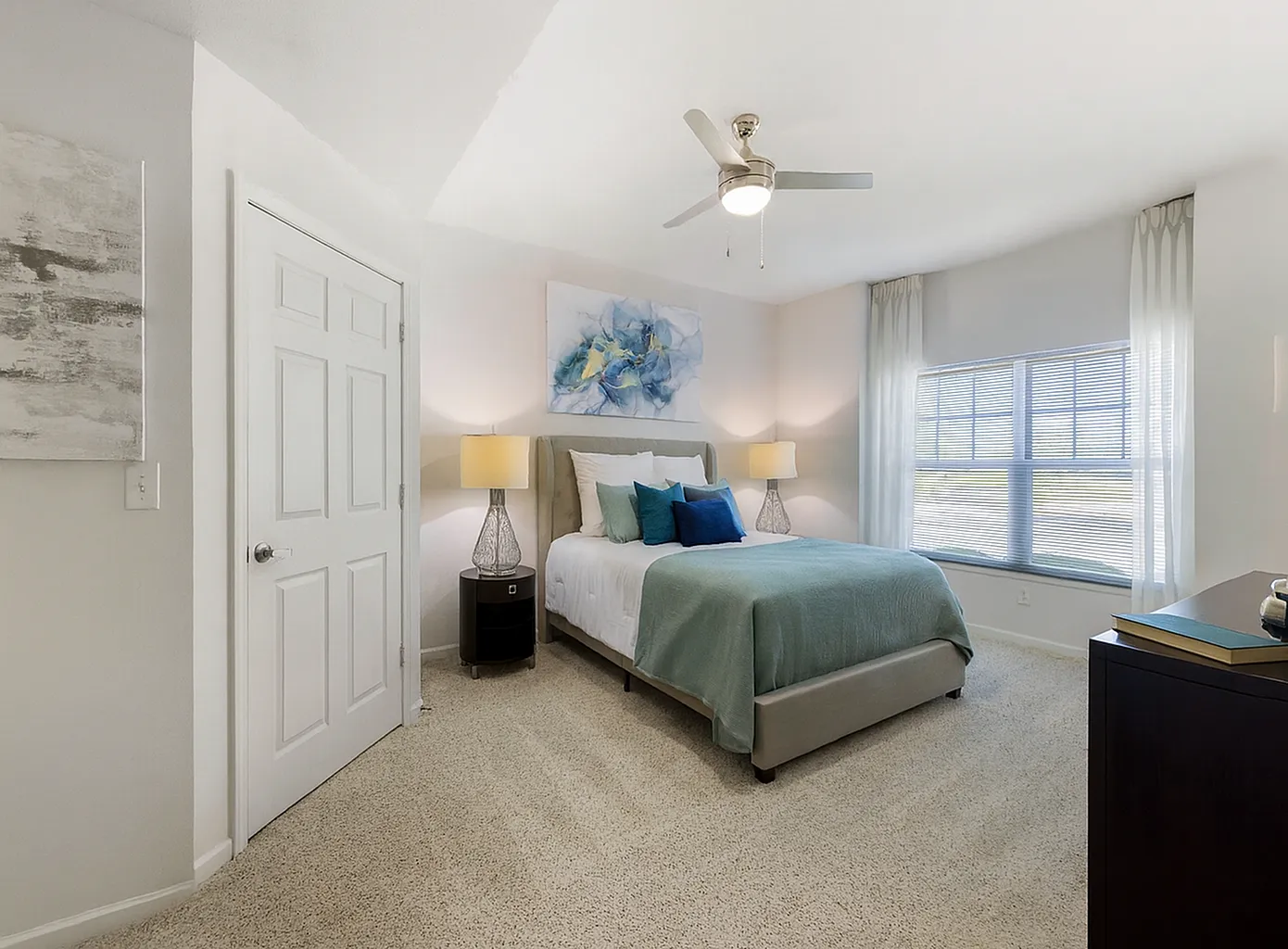 Bright and spacious bedroom featuring elegant neutral decor, plush bedding, and abundant natural light.