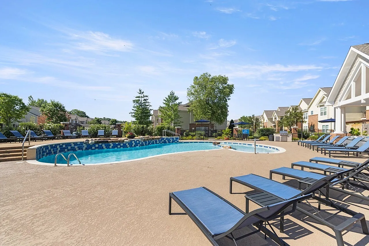 Inviting residential pool area with stylish lounge chairs and lush landscaping, perfect for relaxation and leisure.