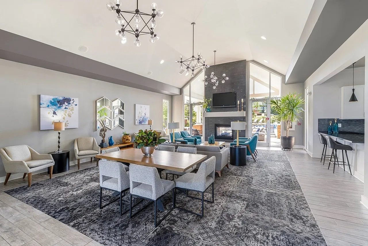 Luxurious open-concept living room with modern decor, elegant chandeliers, and a cozy fireplace, perfect for entertaining.