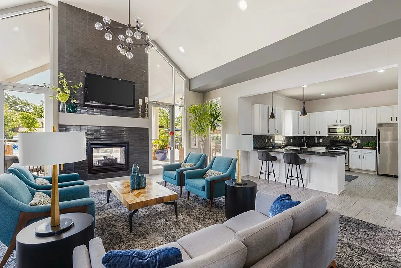 Contemporary open-plan living area with elegant decor, featuring a cozy seating arrangement around a modern fireplace and a sleek kitchen with high-end appliances.