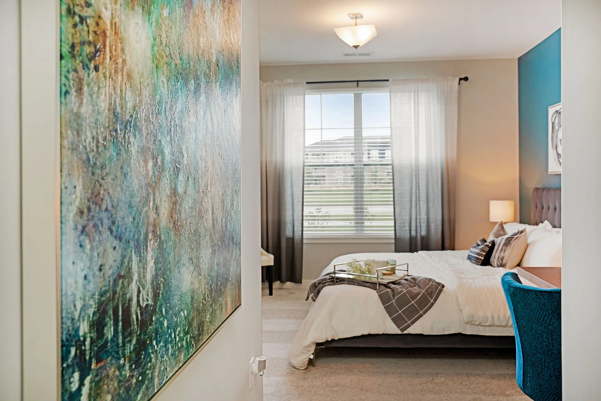 Inviting bedroom with a cozy bed, stylish decor, and a large window providing ample natural light.