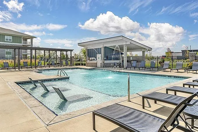 Inviting outdoor pool area with sun loungers and covered seating, perfect for relaxation and leisure in a sunny setting.