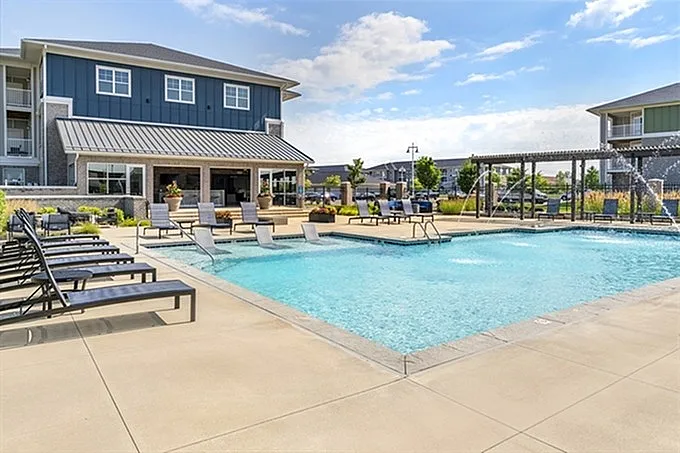 Inviting outdoor pool area with modern lounge chairs and charming pergola, perfect for relaxation and recreation.