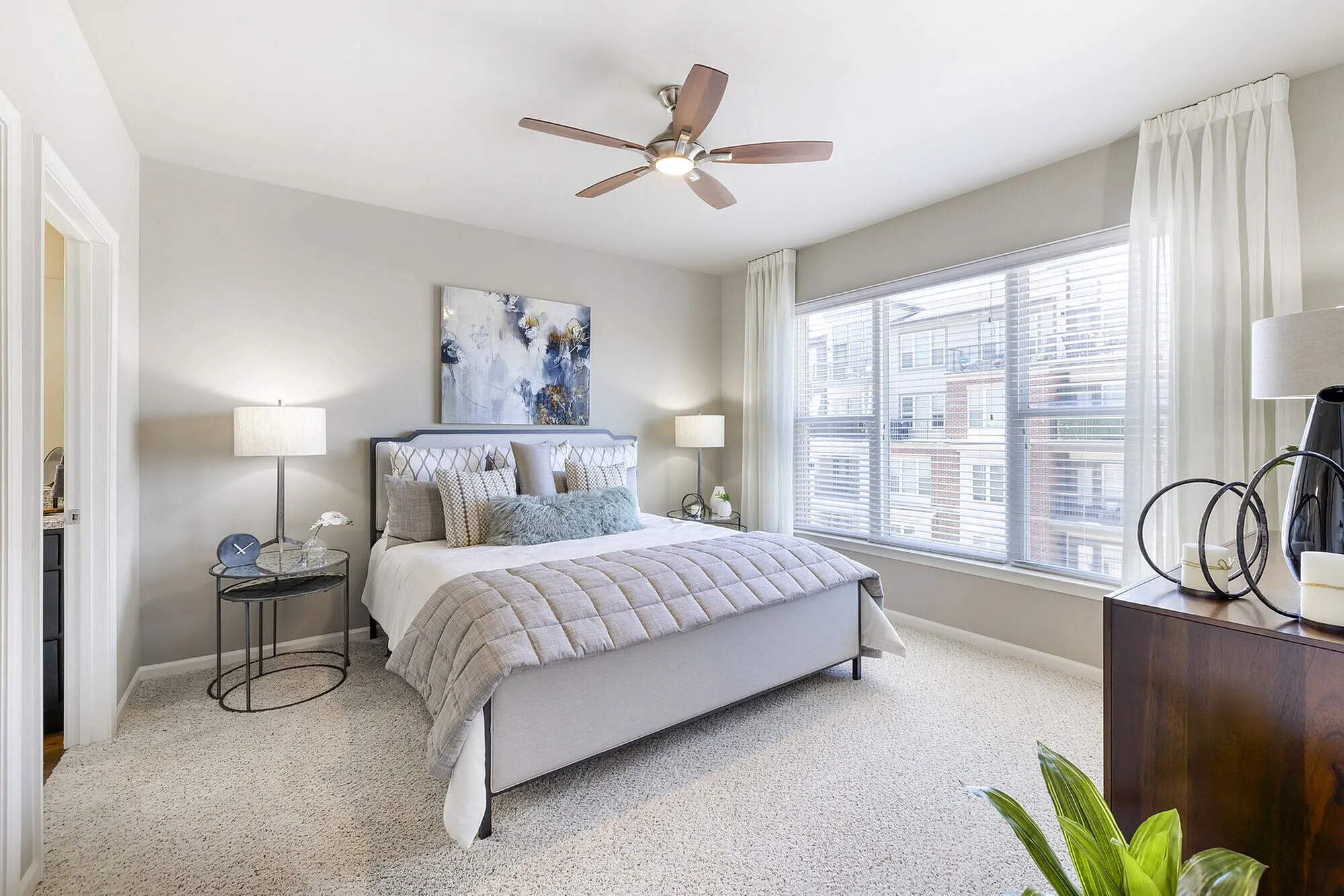 Bright and airy bedroom featuring a plush bed, modern decor, and large window offering ample natural light.