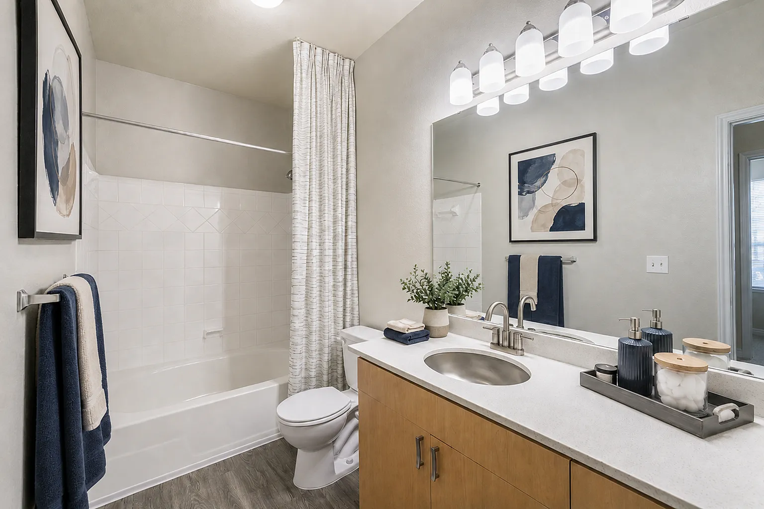 Bright and modern bathroom featuring elegant lighting, sleek vanity, and tasteful decor for a luxurious feel.