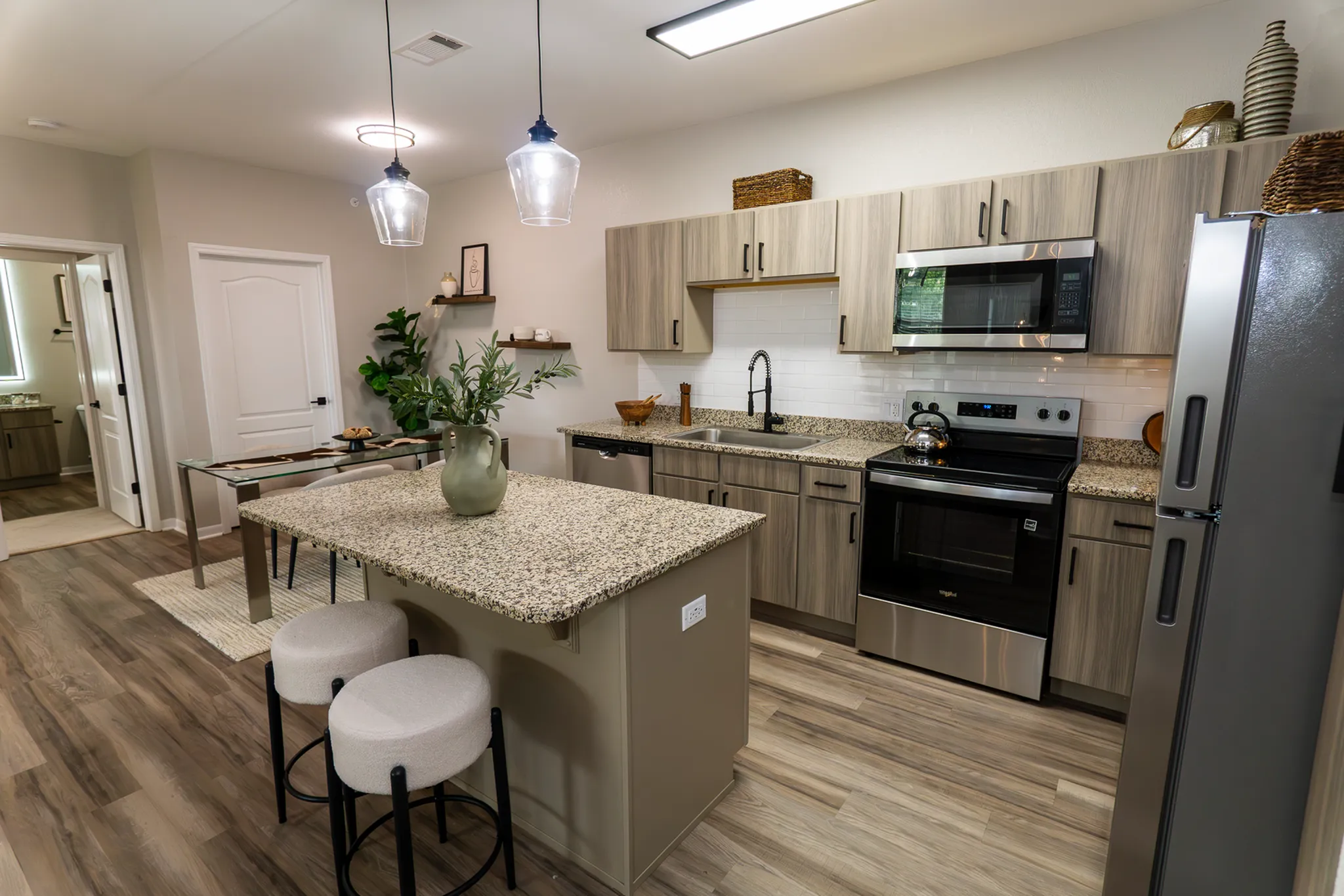 Modern renovated kitchen with granite island, stainless steel appliances and adjacent dining area