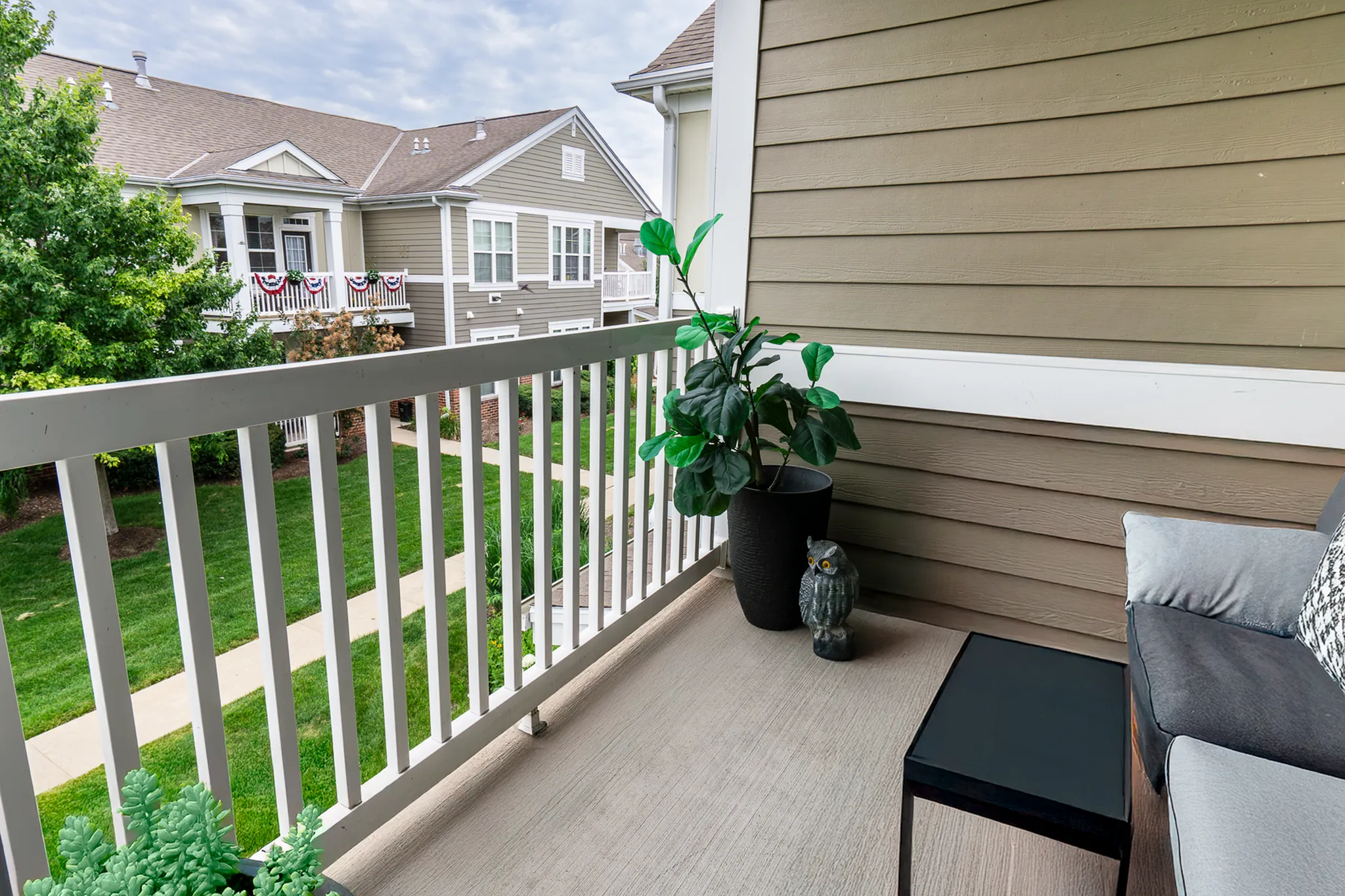 Private apartment balcony overlooking greenery and landscaped community grounds at Enclave at 127th in Plainfield, Illinois