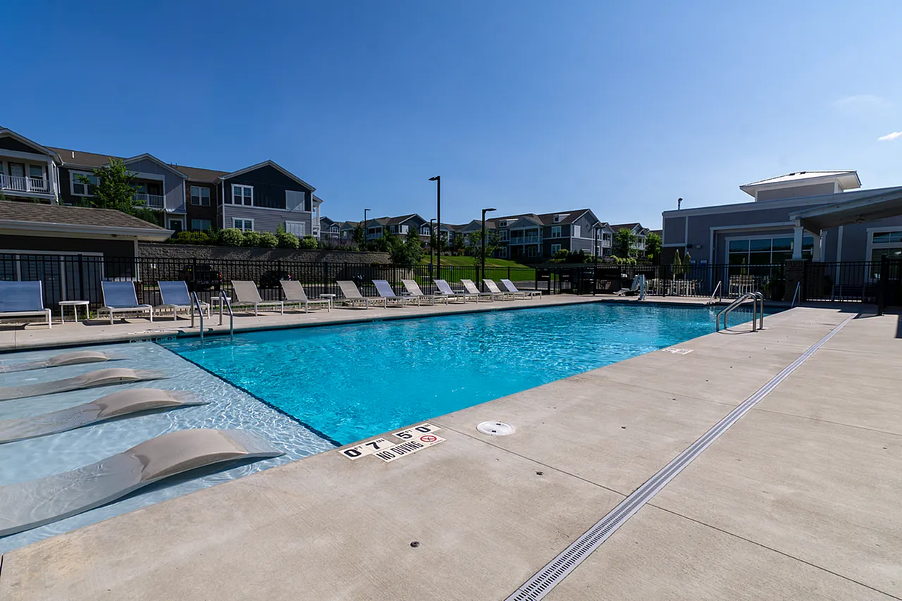 Inviting outdoor pool area with sun loungers and umbrellas, perfect for relaxation and leisure on a sunny day.