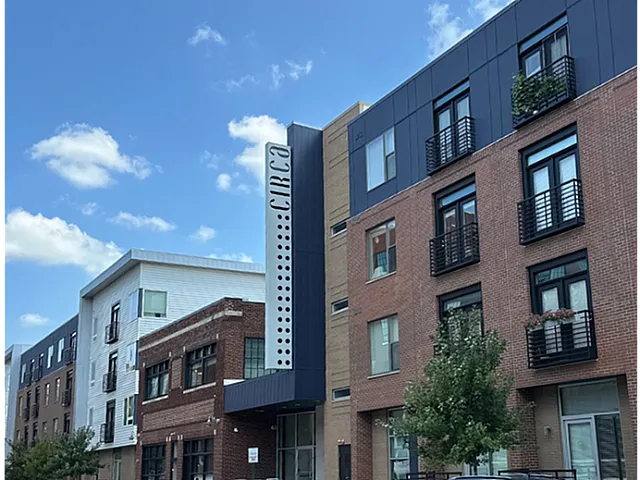 Modern urban apartment building with stylish brick and contemporary exterior, highlighted by sleek windows and vibrant community vibe.