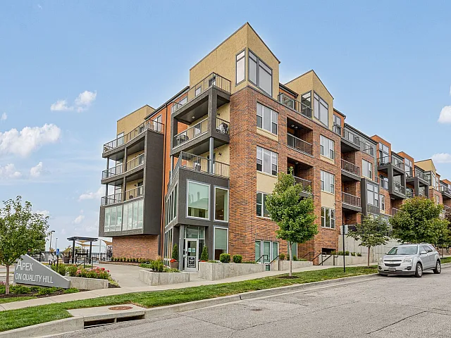 Modern mid-rise apartment building with a stylish brick facade and spacious balconies, located at Apex on Quality Hill, offering urban living with scenic views.
