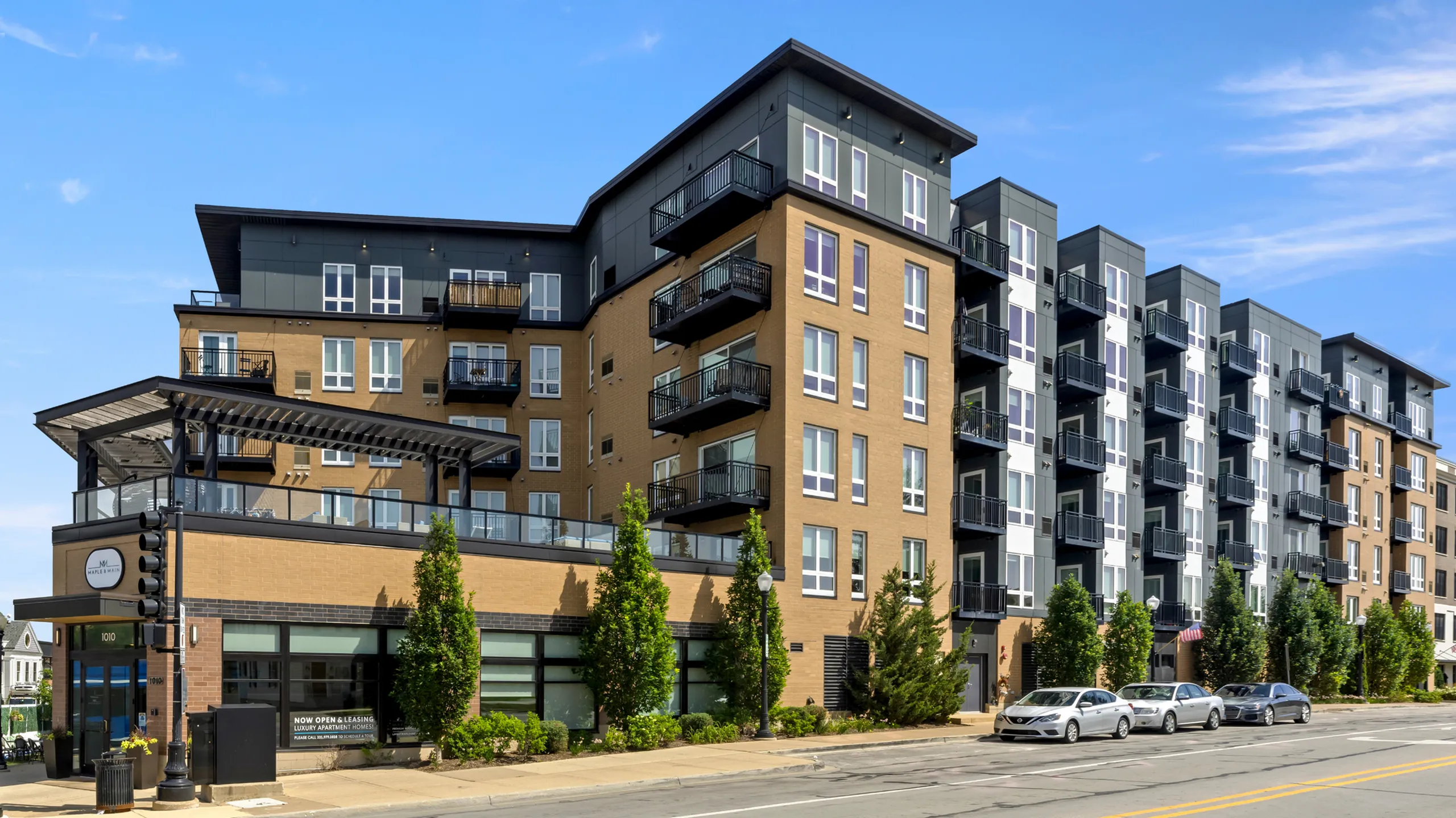 Contemporary multi-story apartment building with sleek balconies and lush greenery, offering modern luxury living and prime urban convenience.