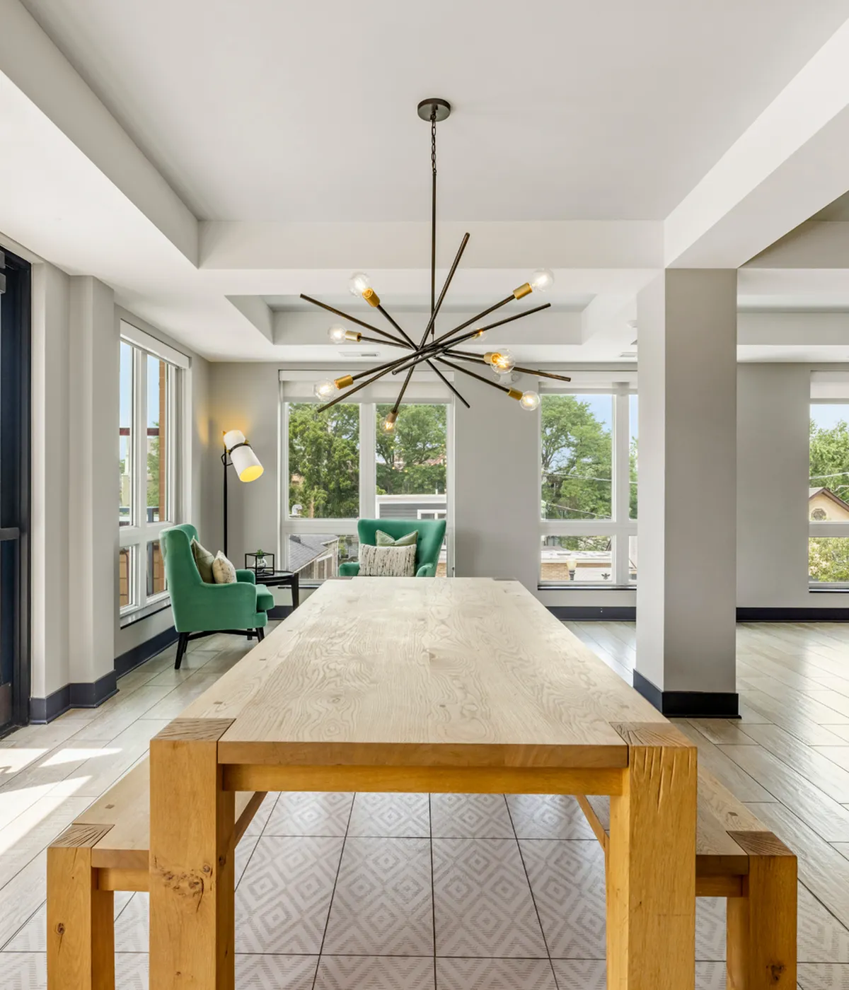 Chic dining area with a modern chandelier, abundant natural light, and elegant seating for a stylish living experience.