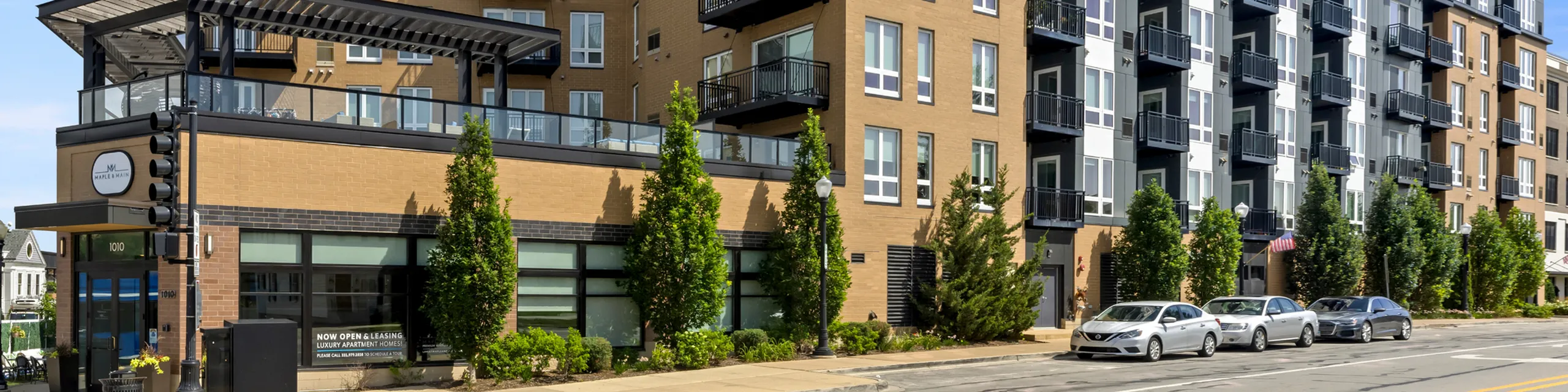 Modern luxury apartment exterior showcasing elegant design, expansive outdoor patio, and stylishly landscaped surroundings.