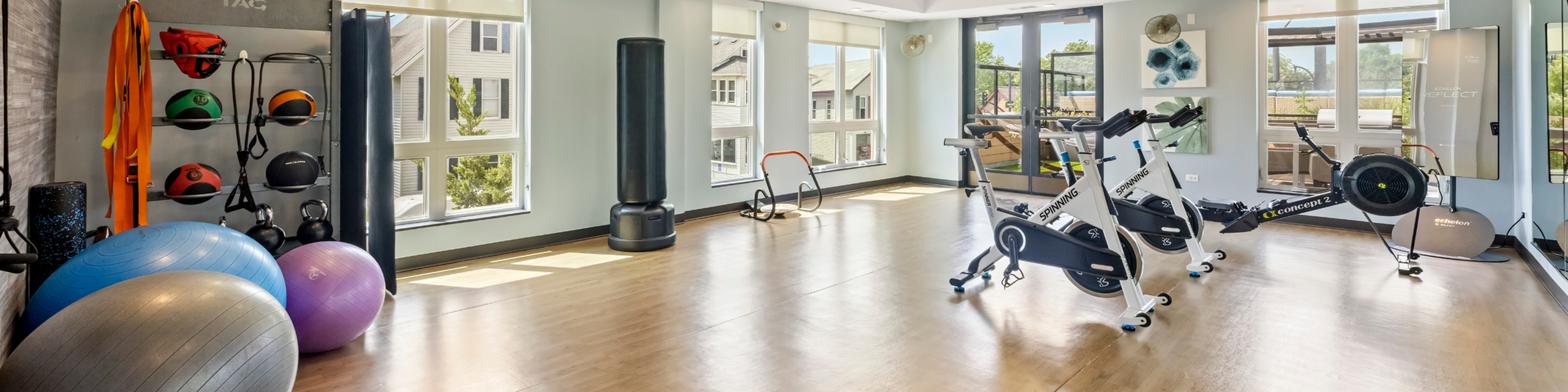 Bright and modern fitness room featuring spinning bikes, resistance bands, and exercise balls, perfect for an invigorating workout experience.
