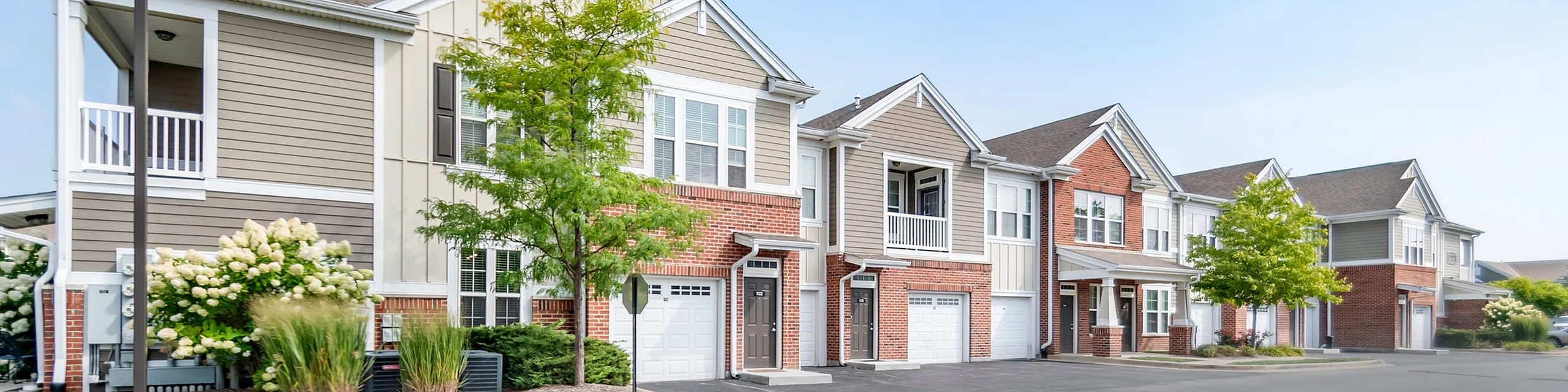 Charming townhouse community featuring modern architecture, lush greenery, and private garages, perfect for family living.