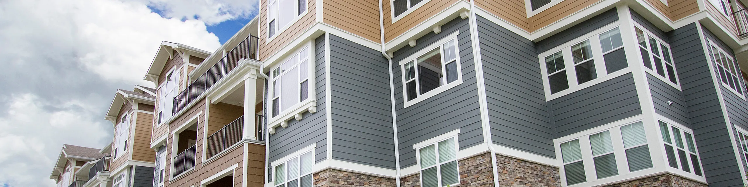 Modern multi-story apartment building with elegant exterior design and large windows, perfect for a vibrant urban lifestyle.