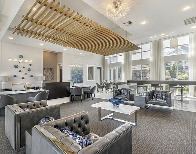 Elegant and contemporary sitting area with plush leather sofas, stylish decor, and grand windows offering abundant natural light.