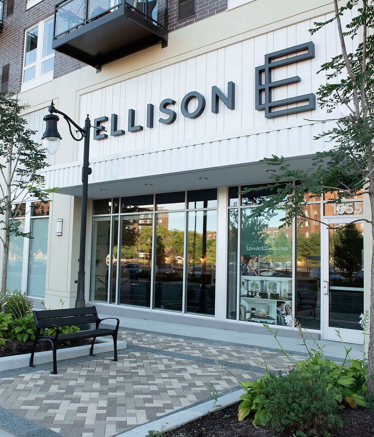 Chic urban apartment exterior with large glass windows at Ellison E, showcasing modern design and welcoming outdoor space.