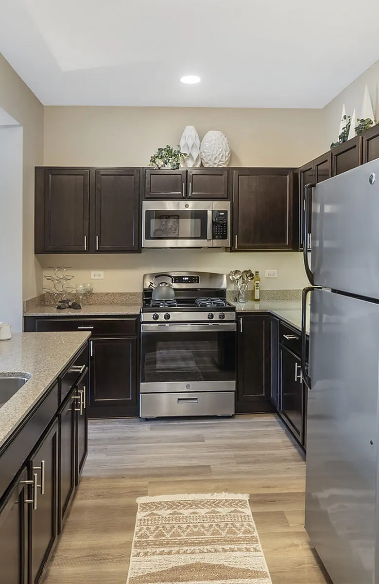 Modern kitchen with sleek stainless steel appliances, rich dark cabinetry, and elegant granite countertops.