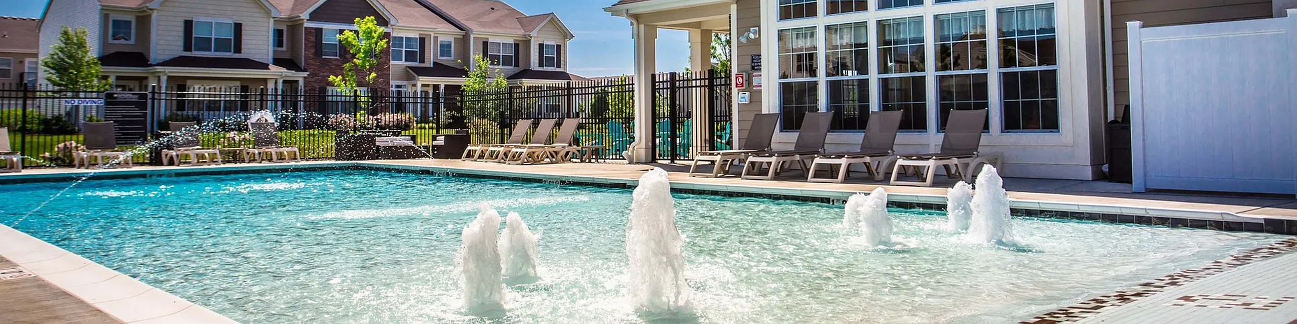 Inviting outdoor pool area with sun loungers and elegant water features, ideal for relaxation and leisure.
