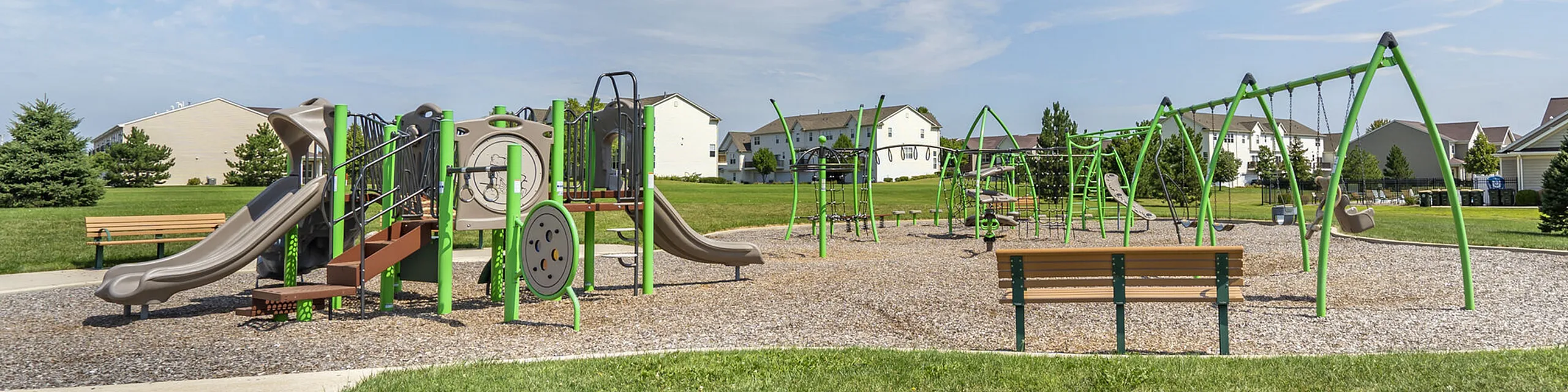 Inviting community playground with modern equipment, surrounded by lush green spaces and charming residential homes.