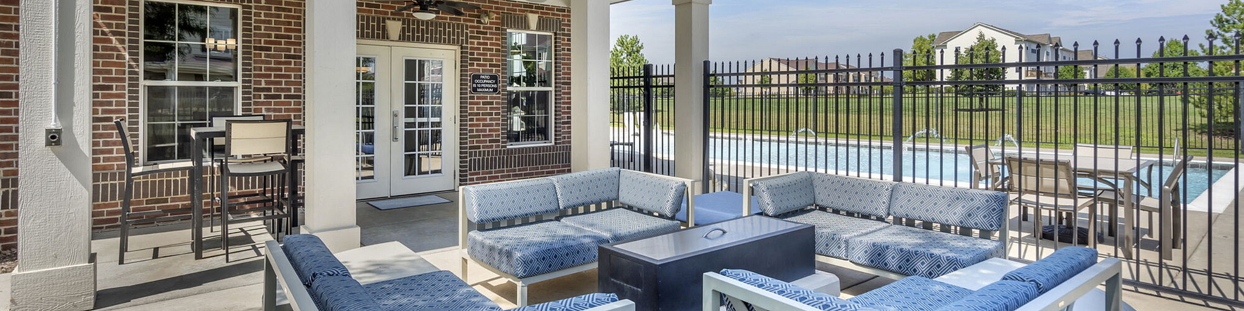 Inviting outdoor patio with stylish seating overlooking a sparkling pool, ideal for relaxation and social gatherings.