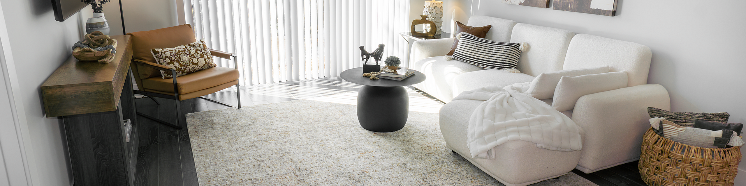 Chic modern living room with cozy white sofa, stylish armchair, and elegant decor, bathed in natural light.