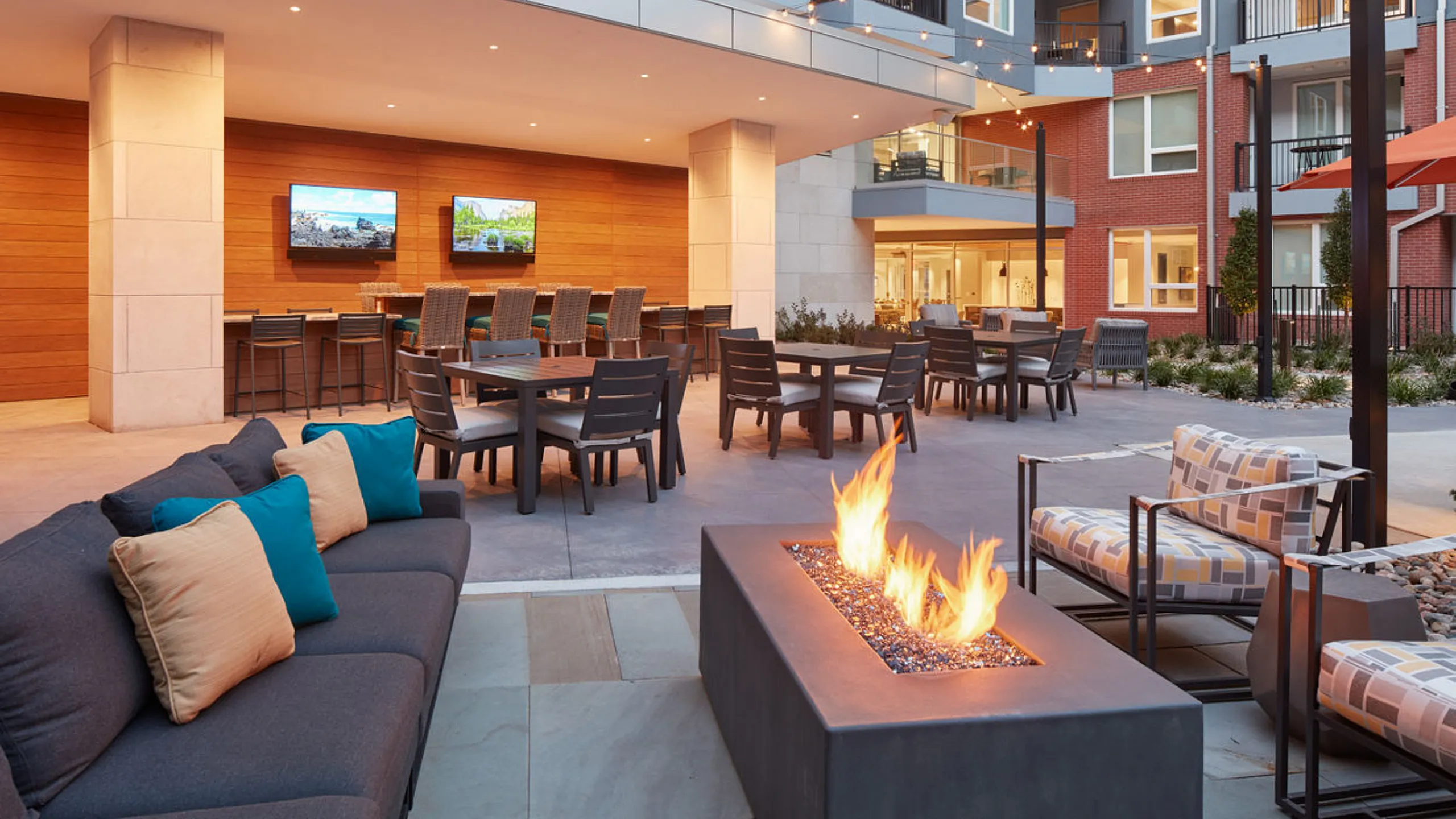 Luxurious outdoor patio with modern fire pit, cozy seating, and dining area, perfect for relaxation and entertaining.