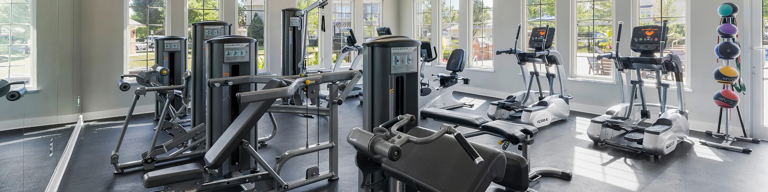 Bright and modern gym filled with state-of-the-art fitness equipment, offering a welcoming and energetic workout space.