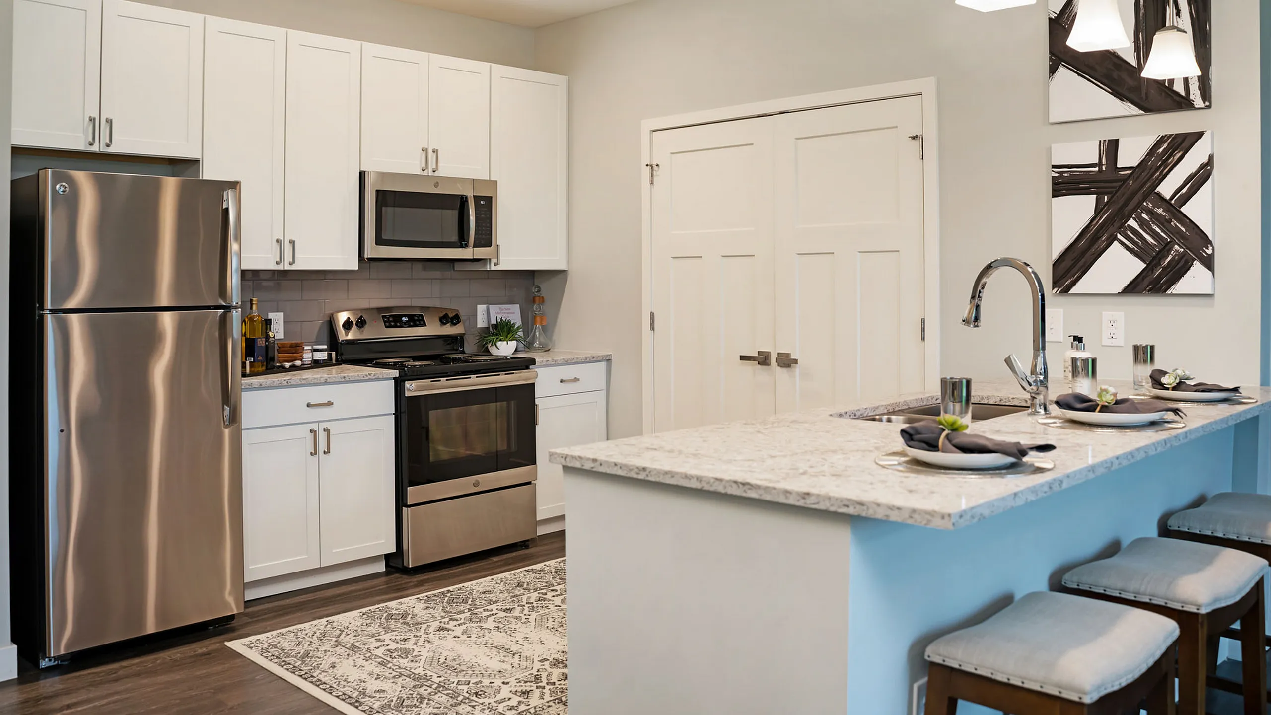 Modern kitchen with sleek stainless steel appliances, elegant white cabinetry, and a stylish breakfast bar with seating.