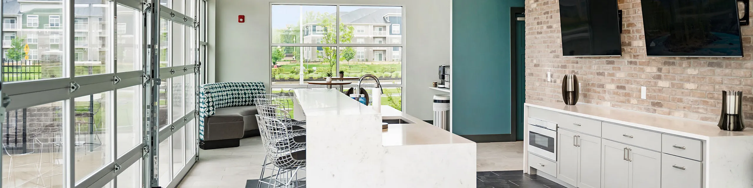 Bright and modern kitchen and seating area with large windows, sleek countertops, and stylish decor. Perfect for social gatherings and relaxation.