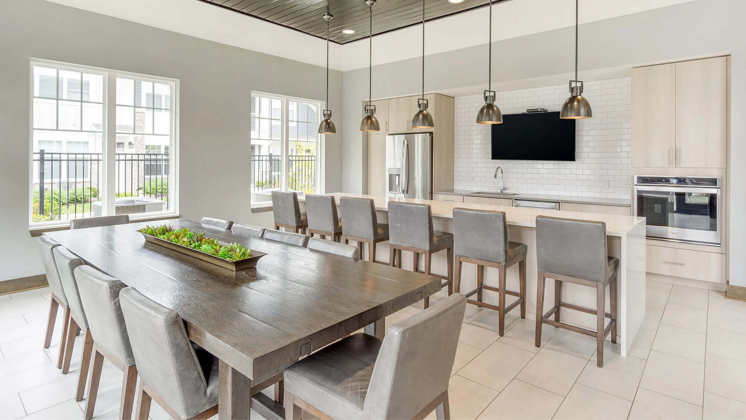 Elegant communal kitchen and dining area with modern finishes, large windows, and stylish pendant lighting.