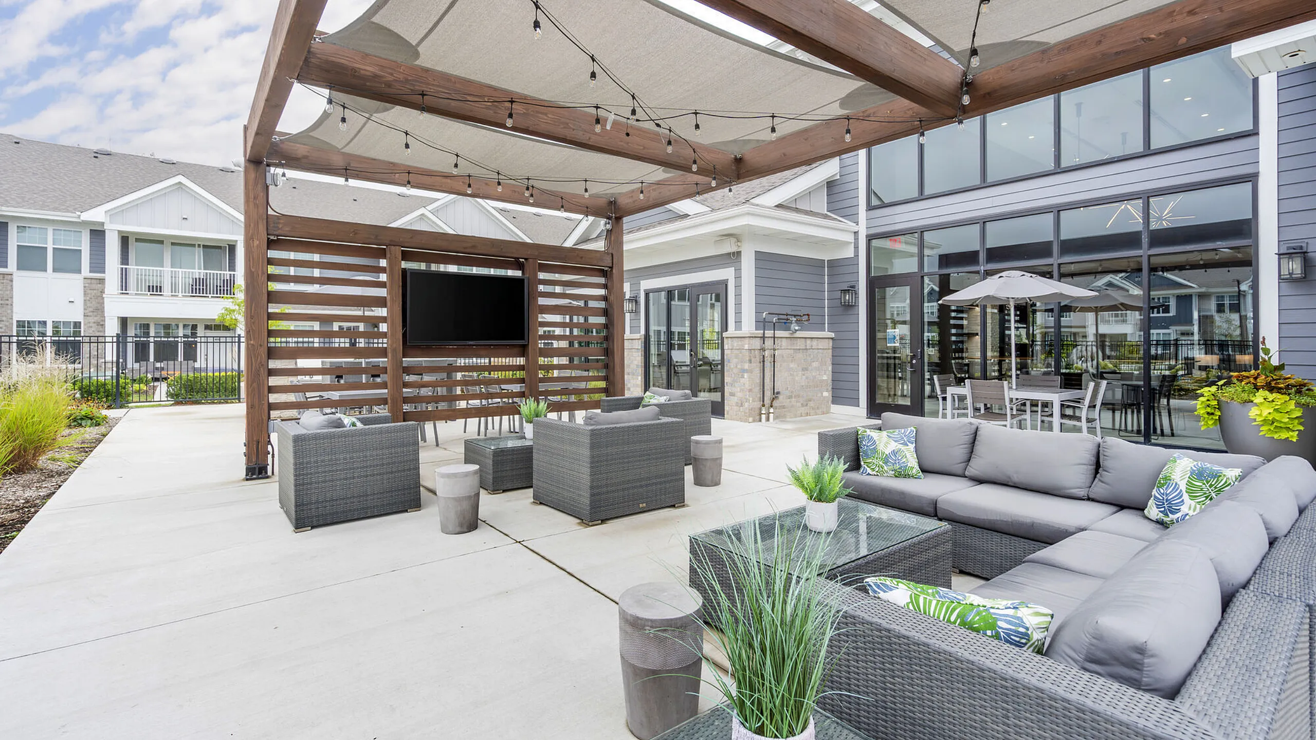 Luxurious outdoor patio with modern furniture and a pergola, perfect for entertaining and relaxation.