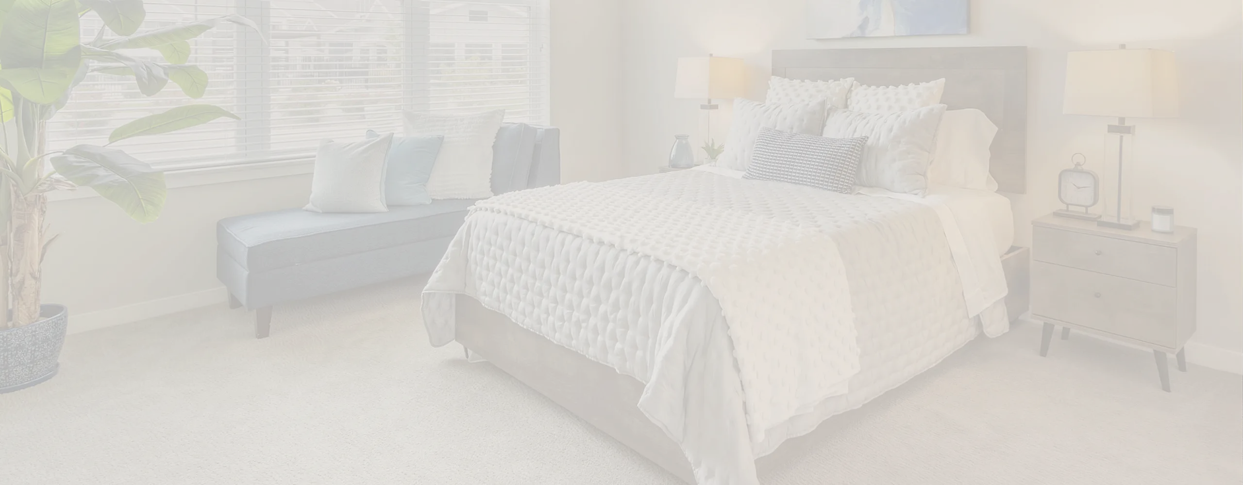 Inviting bedroom with plush bedding, elegant d&eacute;cor, and large window allowing natural light; perfect for tranquil retreats.