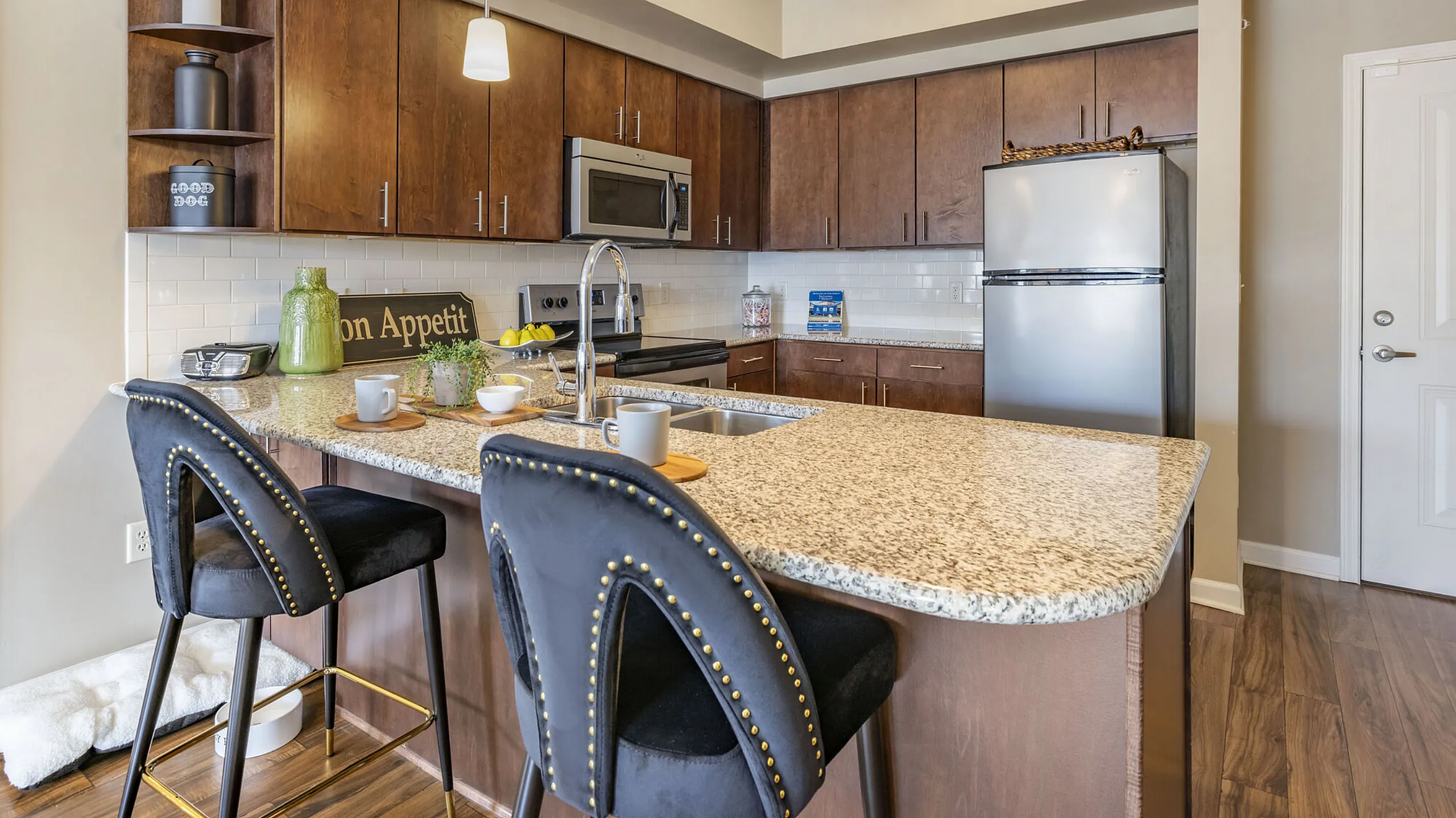 Elegant modern kitchen with sleek granite countertops, chic pendant lighting, and stylish bar stools, perfect for culinary delights.
