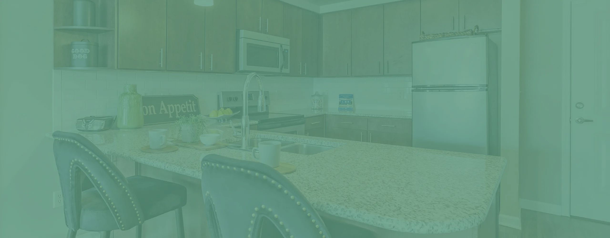 Modern kitchen with sleek cabinetry, marble countertops, and built-in stainless steel appliances. Cozy breakfast bar with stylish seating offers a welcoming atmosphere.