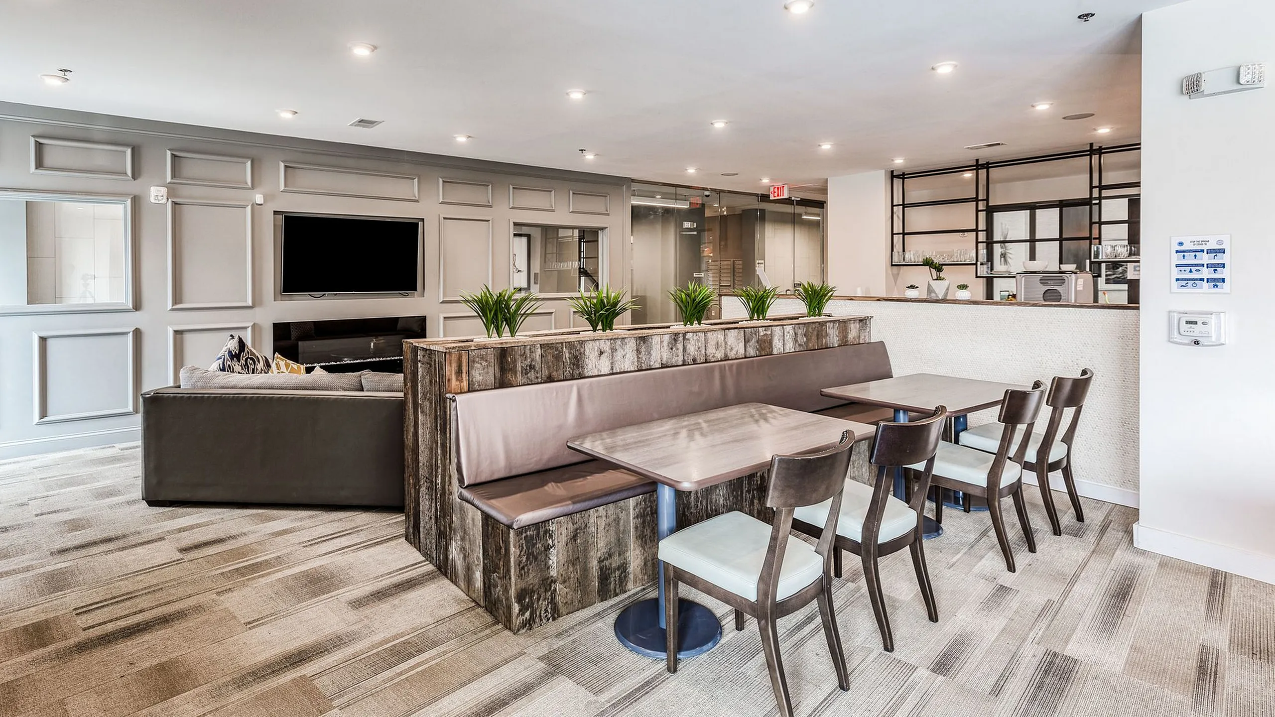 Elegant lounge area with modern decor featuring cozy seating, a wall-mounted TV, and stylish dining tables, perfect for relaxation and social gatherings.