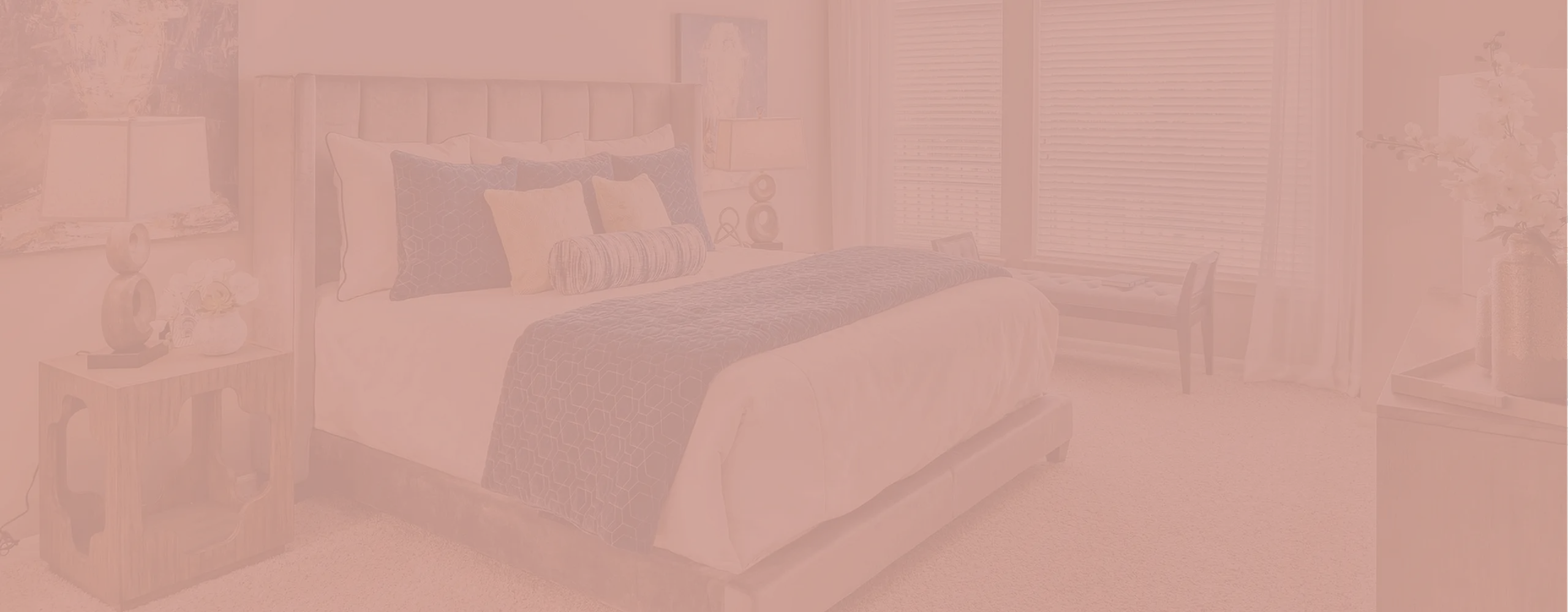 Inviting bedroom with plush upholstered bed, elegant decor, and abundant natural light from large windows.