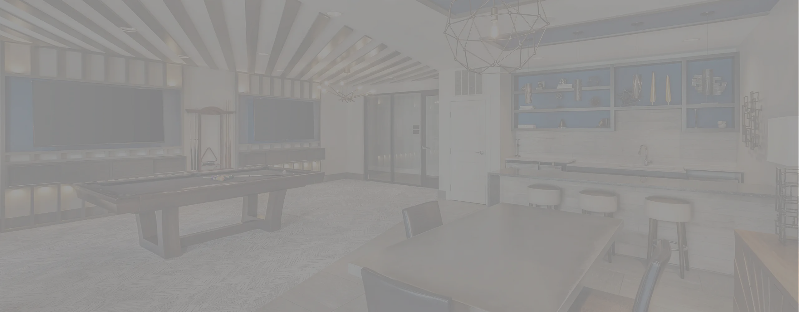 Modern entertainment room featuring a sleek billiards table, lounge seating, and a stylish bar counter with contemporary shelving.