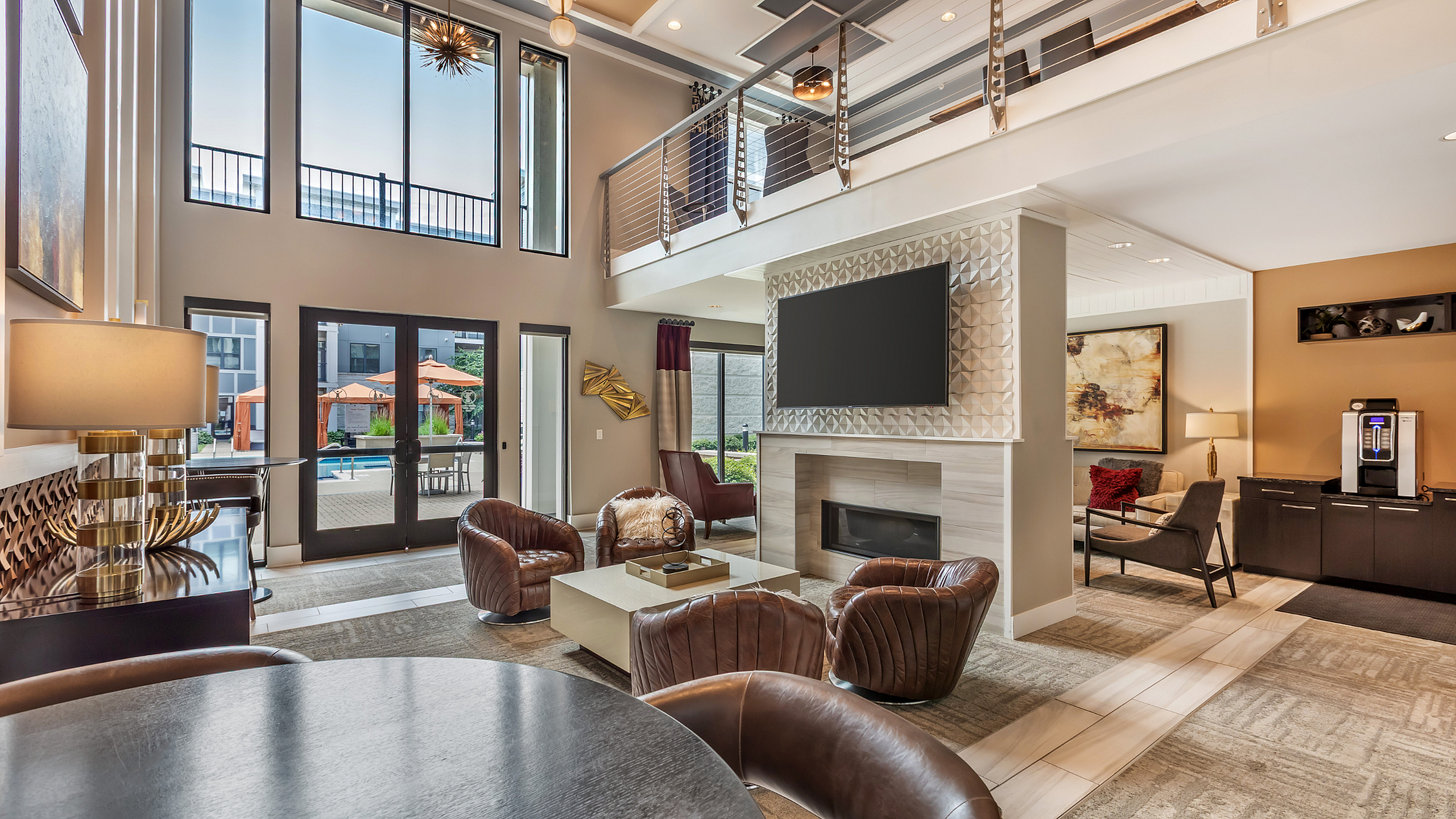 Luxurious modern living room with high ceilings, elegant furnishings, and a stunning pool view through large windows.