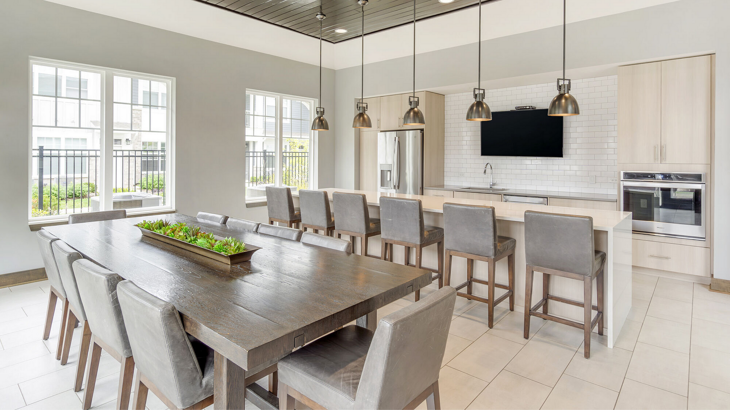 Elegant communal kitchen and dining area with modern finishes, large windows, and stylish pendant lighting.