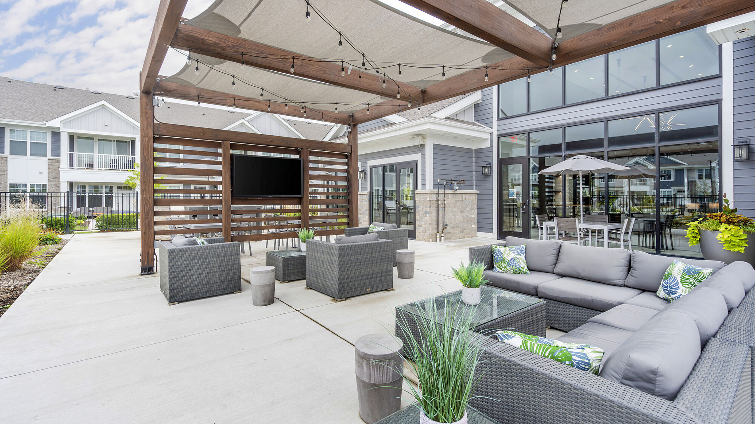 Luxurious outdoor patio with modern furniture and a pergola, perfect for entertaining and relaxation.